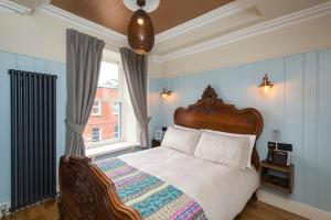 Schlafzimmer mit einem Bett und einem Fenster in der Unterkunft McGettigan's Townhouse - Olives & Figs Bistro in Dublin