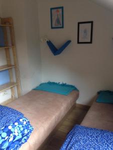 two beds in a room with blue sheets at Pestka in Jastarnia