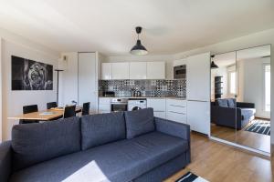 uma sala de estar com um sofá azul e uma cozinha em A 5 min de Bordeaux centre - Terrasse - Pied du tram em Cenon
