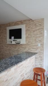 a living room with a tv on a wall at Loft Aconchegante em Petrópolis in Petrópolis