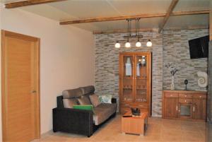 a living room with a couch and a brick wall at Casa Vazquez Sanxenxo La Lanzada in O Grove