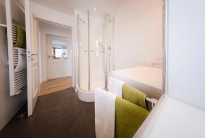 La salle de bains est pourvue d'une douche et d'une baignoire. dans l'établissement Alpenherz-Wallgau, à Wallgau