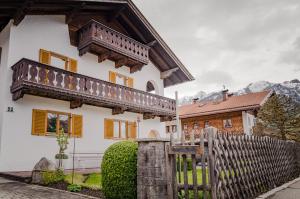 une maison avec une clôture en bois devant elle dans l'établissement Alpenherz-Wallgau, à Wallgau