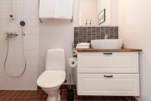 a bathroom with a white toilet and a sink at Hotelli Rakuuna in Lappeenranta