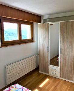 a bedroom with a cabinet and a window in it at La Chaumière d'Hérens in Vernamiège