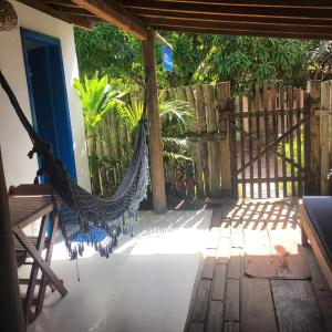 a hammock on the porch of a house at Pousada Três Marias Caraíva in Caraíva