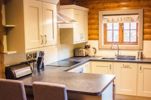 a kitchen with white cabinets and a counter top at High Oaks Grange - Lodges in Pickering +32 photos