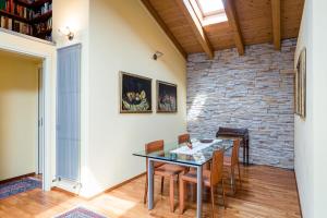uma sala de jantar com mesa e cadeiras e uma parede de tijolos em Sentirsi a Casa em Boario Terme
