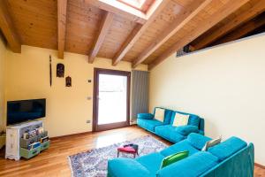 uma sala de estar com dois sofás azuis e uma televisão em Sentirsi a Casa em Boario Terme