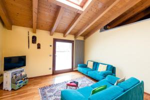 a living room with two blue couches and a television at Sentirsi a Casa in Boario Terme
