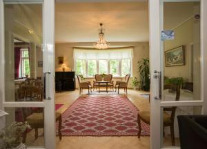 a living room with a table and chairs and a rug at Villa Helleranta in Ulvila