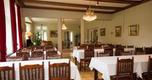 a dining room with white tables and chairs at Villa Helleranta in Ulvila