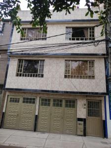 un edificio con cuatro puertas de garaje en una calle en La Cachaca, en Bogotá