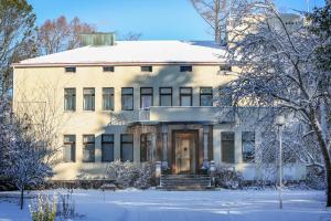 a large white building with snow on the ground at Villa Helleranta in Ulvila