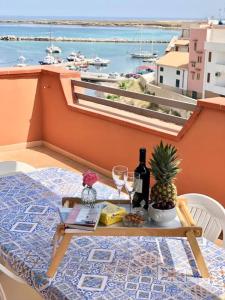einen Tisch mit Weingläsern und eine Ananas auf dem Balkon in der Unterkunft By the Sea in Terrasini