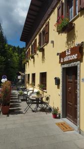 a building with a table and chairs in front of it at B&B Lo Slittone in Abetone