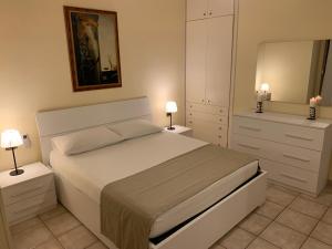 1 dormitorio con 1 cama con 2 mesitas de noche y espejo en Holiday Dreams, en Francavilla al Mare