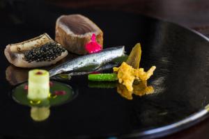 un plato de comida con pescado y otros alimentos en L'Auberge Basque-Relais & Châteaux en Saint-Pée-sur-Nivelle