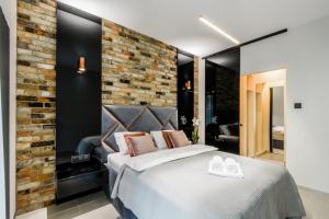 a bedroom with a bed and a brick wall at ZLOTA Luxury Apartments in Warsaw