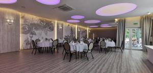 a dining room with white tables and chairs and purple lights at Hotel Sevilla Gold in Łęczeszyce