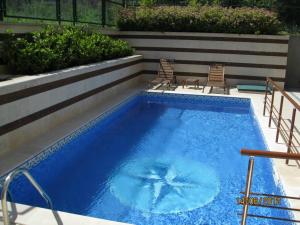 una gran piscina azul con 2 sillas junto a ella en Villa Allegra, en Kavarna