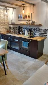 uma cozinha com um lavatório e um fogão em La Pierre du Grain em Ravel