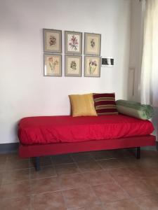 czerwona kanapa w pokoju z obrazami na ścianie w obiekcie Appartamenti a Magnano w mieście Magnano