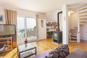 a living room with a couch and a tv and a table at Villa Paradise village in Tucepi, private pool in Tučepi