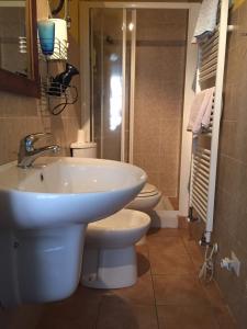łazienka z 2 toaletami i białą umywalką w obiekcie Appartamenti a Magnano w mieście Magnano