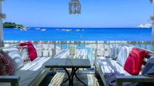 a balcony with a table and a view of the ocean at Bloom Villa By the sea in Agia Pelagia
