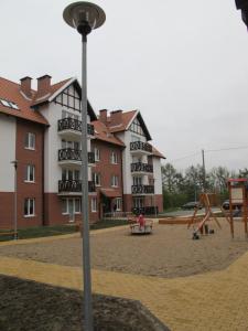 um edifício de apartamentos com um parque infantil em frente em Apartament Baltic em Sztutowo