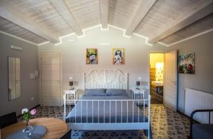 a bedroom with a bed and two tables in a room at B&B La Mia Valigia in San Lucido