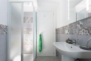 a white bathroom with a sink and a shower at Tyche in Siracusa