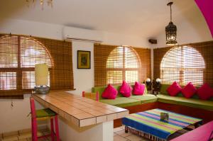 a living room with pink pillows on a green couch at Hotel Casa Alvarada in Comala