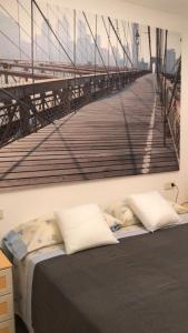 ein Schlafzimmer mit einem Bett mit einem Gemälde einer Brücke in der Unterkunft Apartament L'Alba 2 in Tossa de Mar