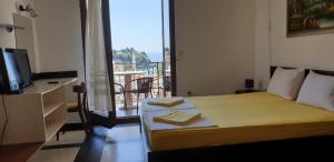 a room with a bed and a balcony with a television at Apartments Prag in Ulcinj