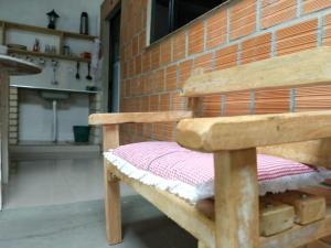a wooden bench in a room with a brick wall at Hospedaria Gaúcha in Penha +45 photos