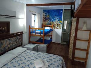 1 dormitorio con 1 cama y 1 litera en Hospedaria Gaúcha, en Penha
