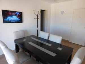 a dining room with a black table and white chairs at DEPARTAMENTO en PEATONAL con HERMOSA VISTA in Concordia