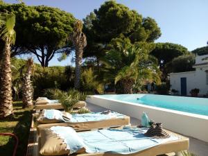 een zwembad met ligstoelen naast een resort bij Kasbah Andaluz guest house in Chiclana de la Frontera