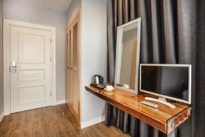 een televisie op een houten tafel in een kamer bij Eliada Hotel in Kuşadası