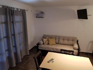 ein Wohnzimmer mit einem Sofa und einem Tisch in der Unterkunft Posada de la comarca in Sierra de la Ventana
