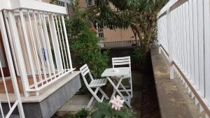 two white chairs and a table on a porch at Clambè in Palermo
