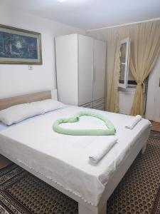 a bedroom with a bed with a green heart on it at Just nature in Novi Sad