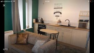 a living room with a couch and a kitchen at 1 Tŷ Mona Church Street Apartment in Llangefni