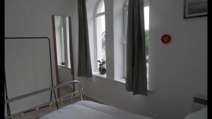 a bedroom with a bed and a window and a mirror at 1 Tŷ Mona Church Street Apartment in Llangefni