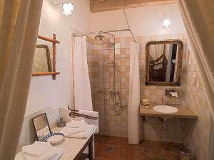 ein Badezimmer mit einem Waschbecken und einer Dusche mit einem Laptop in der Unterkunft Hôtel De La Beursaudiere in Nitry