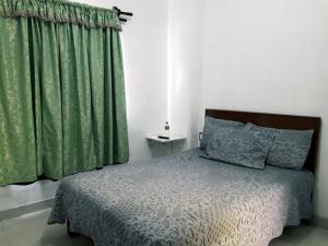 1 dormitorio con 1 cama y cortina verde en Oaxaquita la Bella en Oaxaca de Juárez