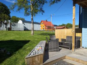 een achtertuin met twee stoelen en een bank op een terras bij 43 Oscarsgate in Vadsø