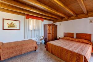a bedroom with two beds and a wooden ceiling at Camere Di Ulisse in Erice